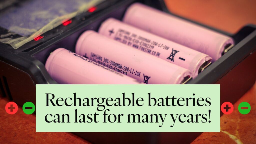 10 Easy Swaps for a More Sustainable Lifestyle 2 Four pink rechargeable batteries are placed in a black charger with red and green indicator lights. The text overlay on a light green background reads, "rechargeable batteries can last for many years! " with red and green plus and minus symbols on either side. The background is a blurred reddish-brown surface.